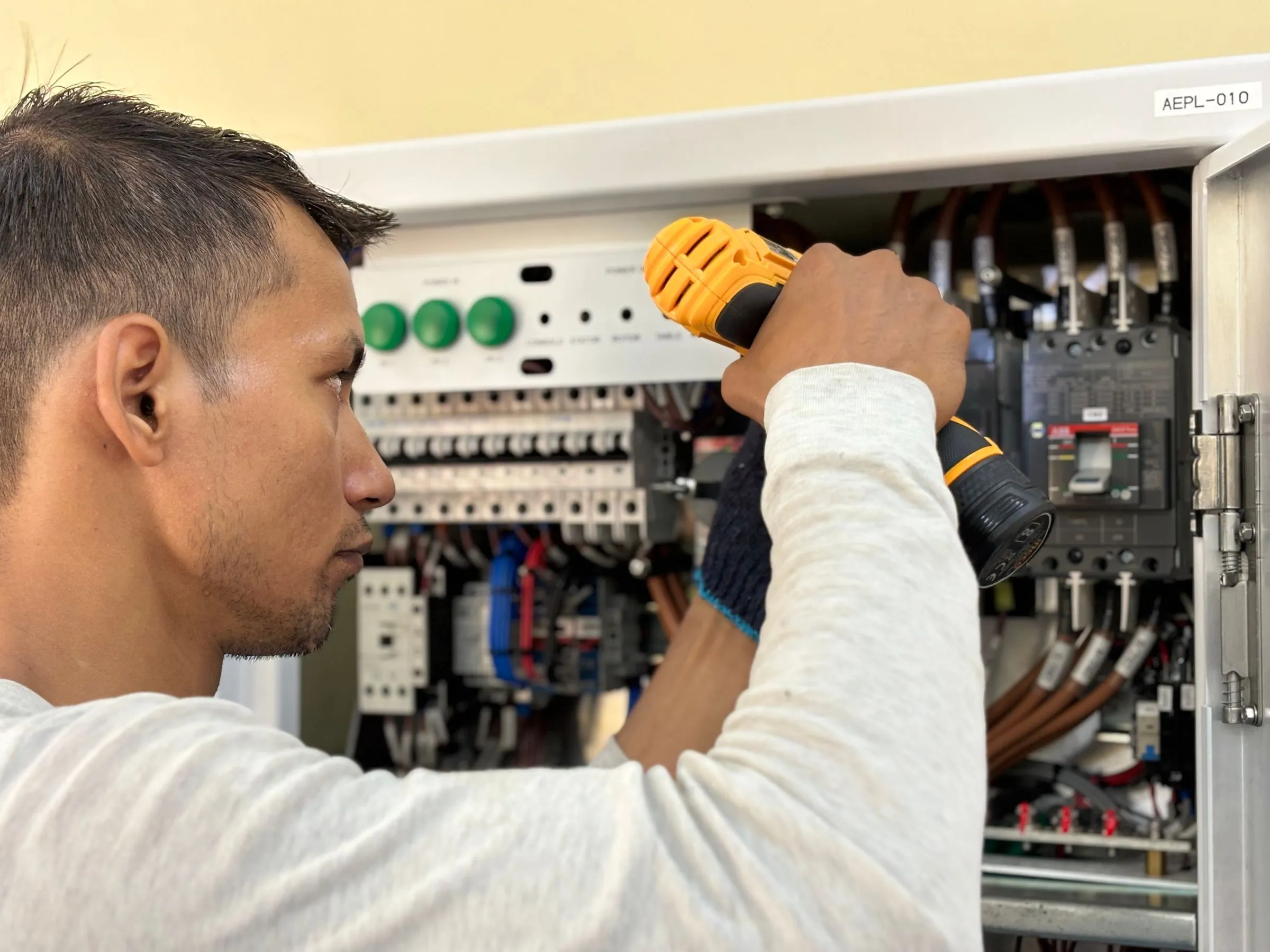 Elektriker montiert Bauteile in einem Verteilerschrank