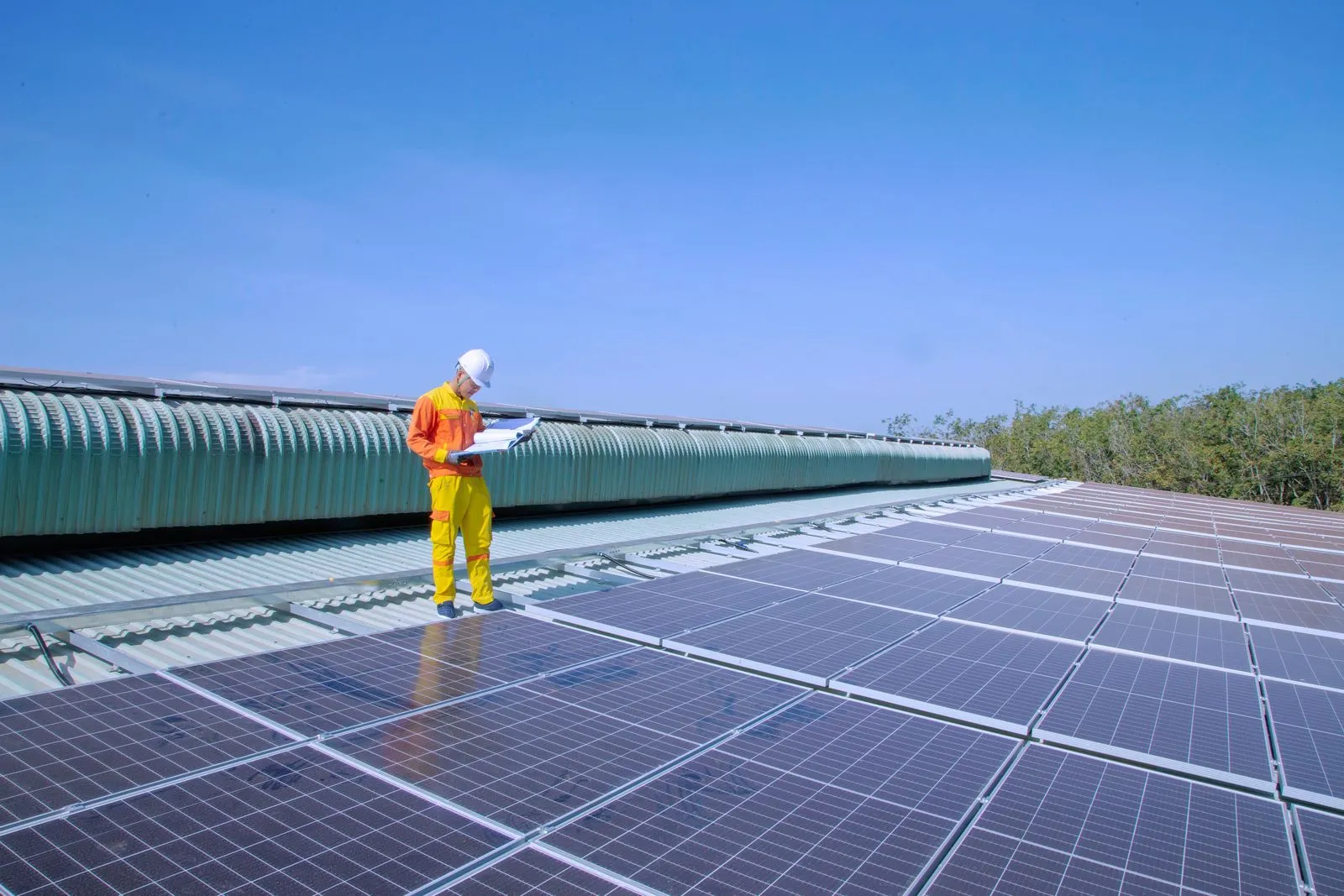 Techniker auf einem Flachdach mit Photovoltaikanlage