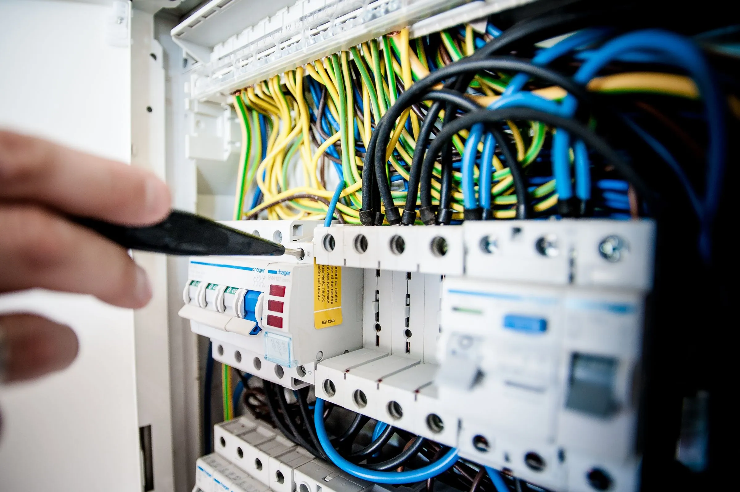 Elektrofachkraft arbeitet an einer geöffneten Unterverteilung